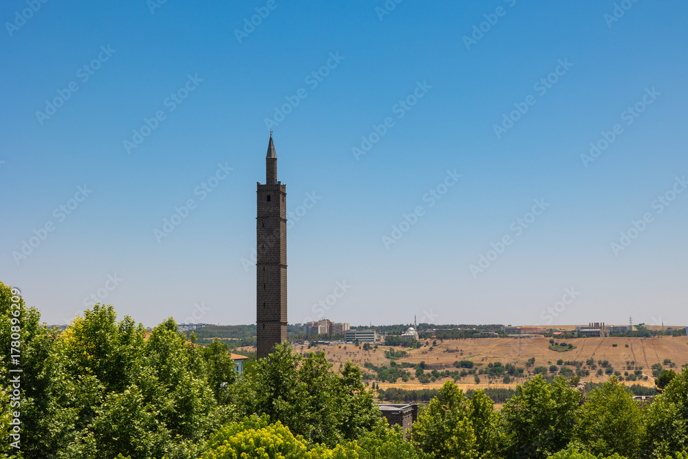 Obraz premium Hazreti Suleyman Mosque's minaret among the trees.