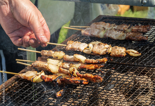 Yakitori chicken skewers grilling over charcoal with smoke in Japan