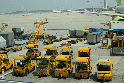 Multiple aircraft pushback tractors and ground support vehicles parked on the tarmac at an airport, ready for aircraft towing and ground operations.