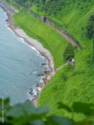 Coastal Railway Line Curving Through Green Hills and Tunnel