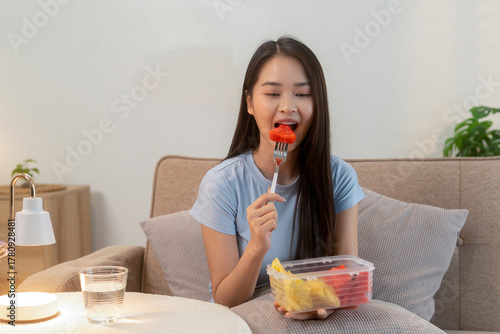 Woman enjoying fresh fruit at home