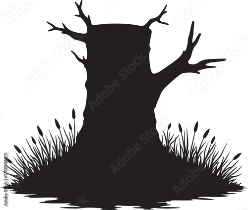 Black silhouette of a dead tree stump with branches and grass