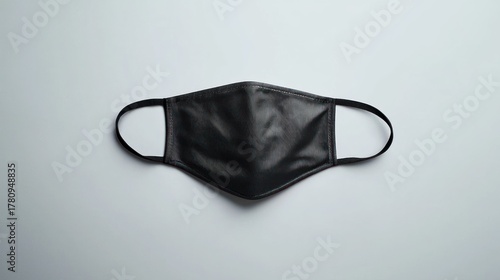 A black leather face mask on a white background.