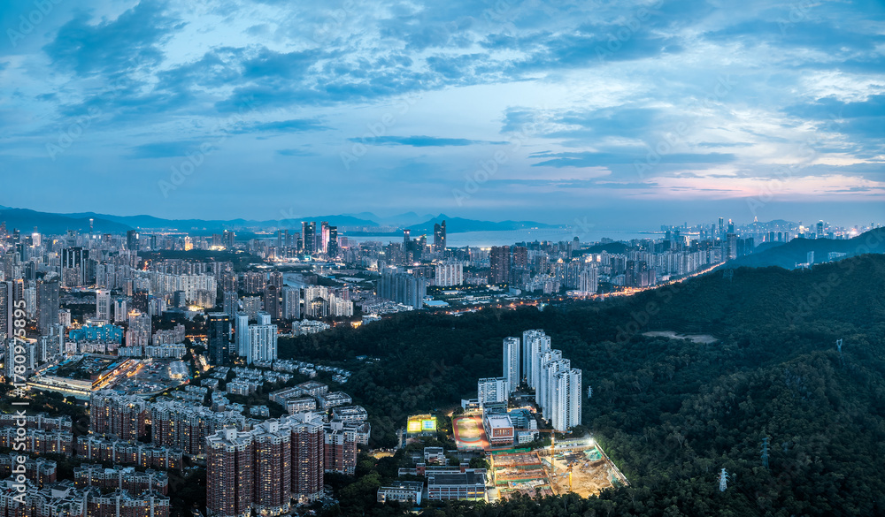Obraz premium Sprawling urban residential area mixed with green hills at dusk in Shenzhen.