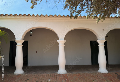 Spanish colonial architectural gallery with white stucco columns and arches - Hacienda-style terrace on a sunny day