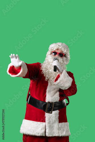 Wallpaper Mural Santa Claus, with a white curly beard, wearing a red suit and sunglasses, sings songs into a microphone and dances cheerfully against a green background. Ideal for Christmas themed compositions. Torontodigital.ca