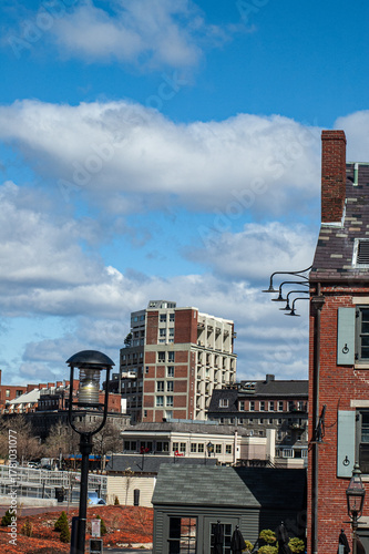 Boston urban residential block with brick-stone apartments over a cloudy blue sky