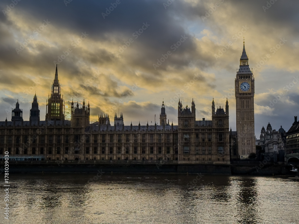 Obraz premium Beautiful night an Sunset view of Big Ben and the Houses of Parliament in London, illuminated over the River Thames with city lights reflecting on the water. UK