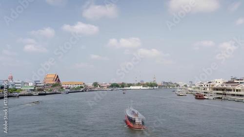 time lapse panorama landscape view of chaopraya river with river water boat transportation and background of bangkok ancient old city skyline with many temple along riverside in daytime
