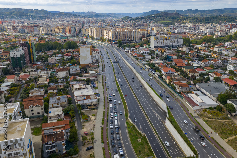 Obraz premium Aerial view of Tirana, Albania, showing the west side of the outer ring road with moving traffic and nearby residential areas.