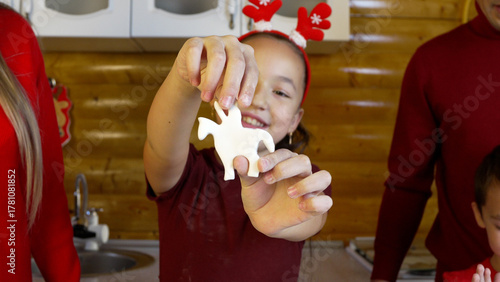 Fotografija A girl is happily holding up a star-shaped Christmas cookie