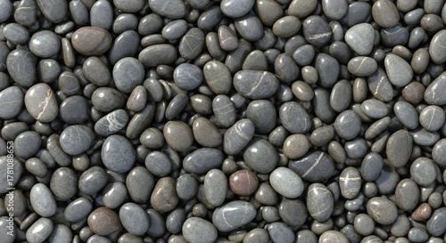 A dense collection of smooth grey and brown pebbles varying in size and shape filling the frame