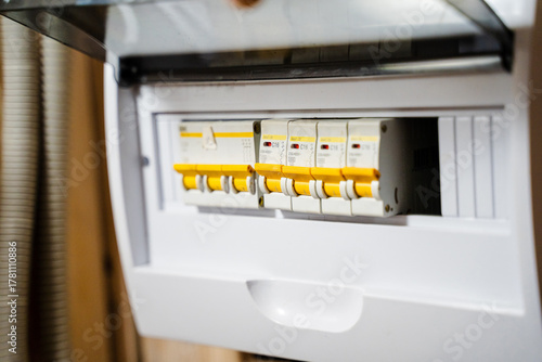 This is a detailed closeup view of an electrical circuit breaker panel that features multiple switches, commonly found in modern homes, showcasing its intricate design and functionality