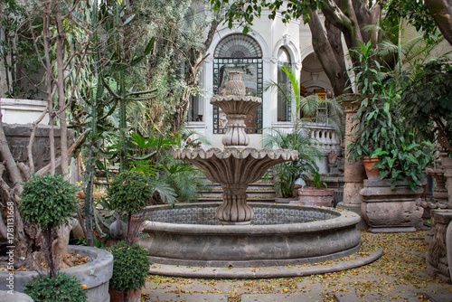 Elegant stone fountain in green courtyard of colonial building in Tlaquepaque, Jalisco