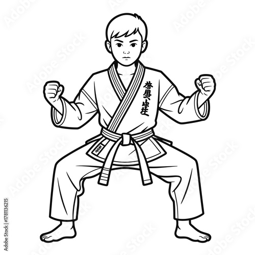 Young boy in karate uniform practicing a defensive stance with fists raised