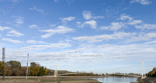 Obraz na plátně Osijek pedestrian bridge stretching across river under vast sky