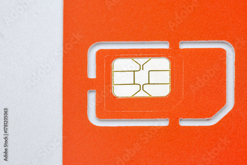 Orange SIM card with golden chip on white background closeup.