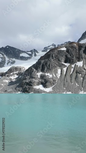 Turquoise Waters of Wedgemount Lake in Whistler with Snow-Capped Mountains and Rushing Stream in BC, Canada