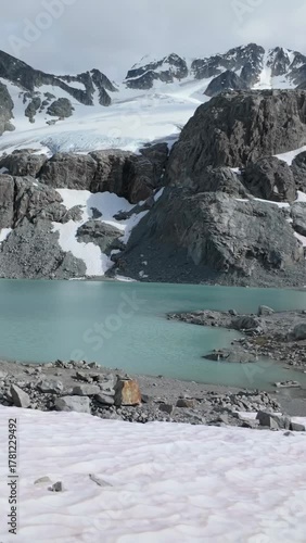 Turquoise Waters of Wedgemount Lake in Whistler with Snow-Capped Mountains and Rushing Stream in BC, Canada