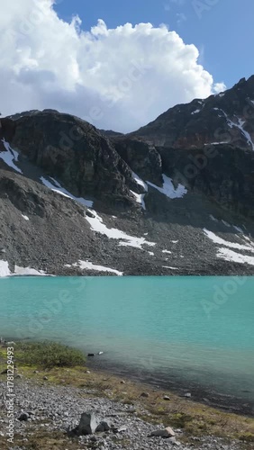 Turquoise Waters of Wedgemount Lake in Whistler with Snow-Capped Mountains and Rushing Stream in BC, Canada
