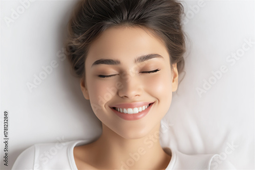 Young woman resting with peaceful smile and closed eyes, concept of relaxation, calmness and mental wellbeing.