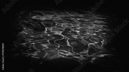 Wave streaks on the water surface, grainy background in a dark frame.
