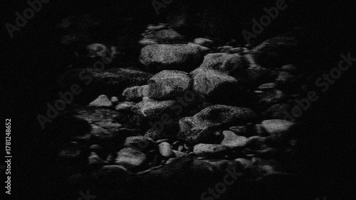 Stones underwater, grainy background in a dark frame.