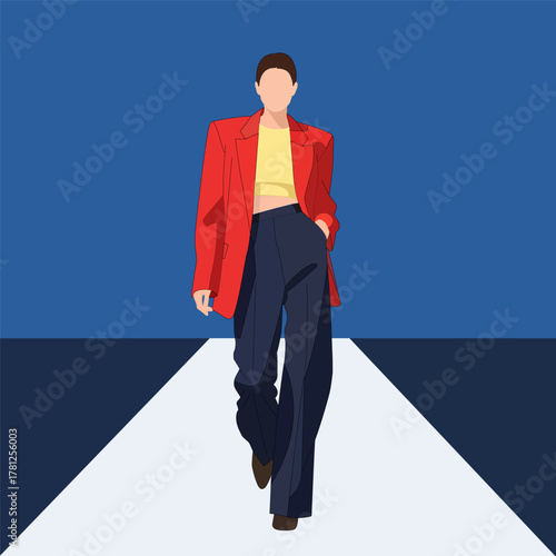 Woman in red blazer walking on a runway during a fashion show event