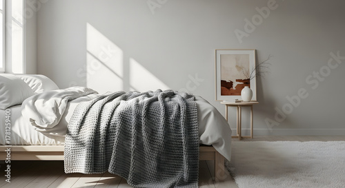 Sunlit bedroom interior with a cozy bed, artwork, and minimalist decor
