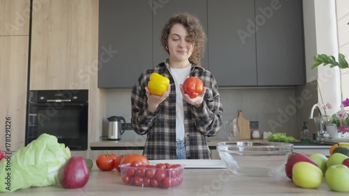 Smiling Woman Holding Bell Peppers While Cooking In Modern Home Kitchen