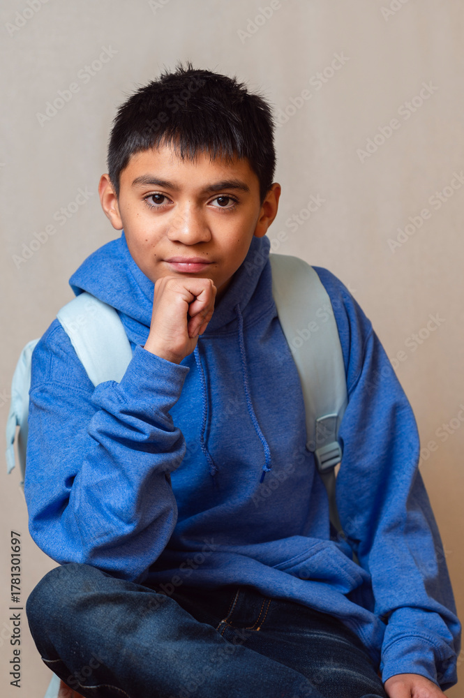 Fototapeta premium Young student with backpack resting chin on hand