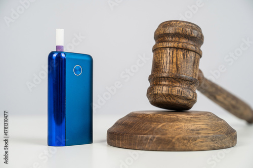Judge's gavel and electronic cigarette. Smoking ban. Tobacco heating systems. 