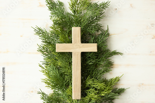 Cross on evergreen branch on white