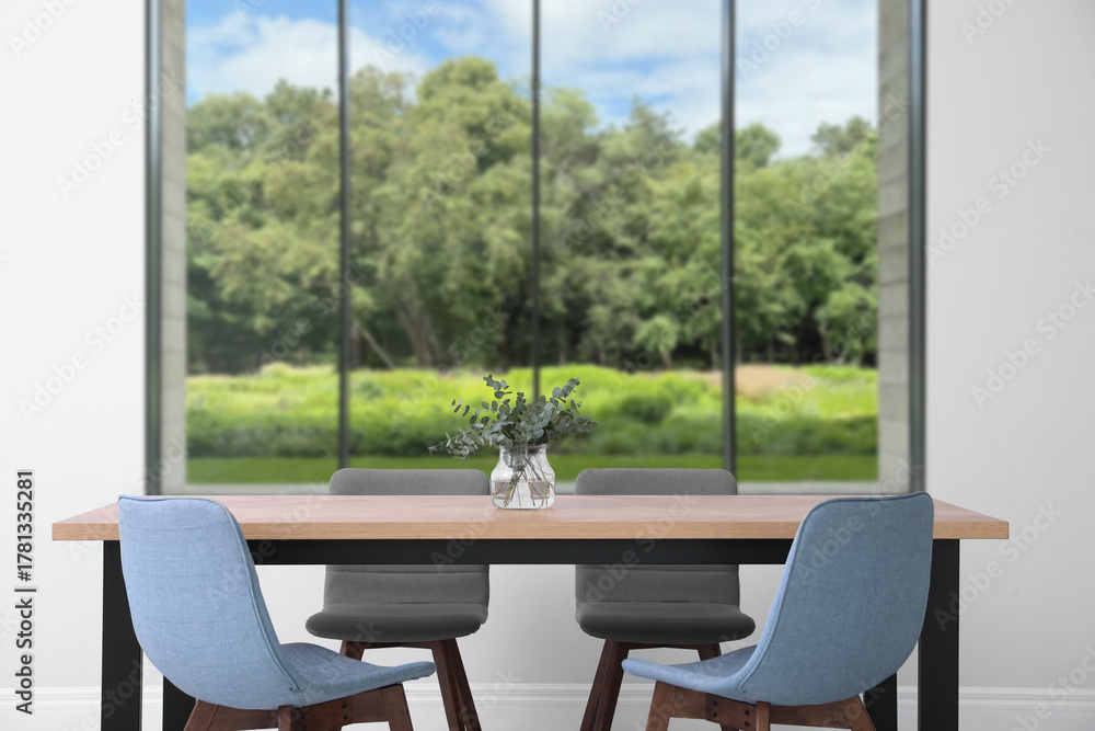 Fototapeta premium Table and chairs near window in room. Interior design