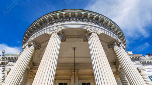 neoclassical building with marble columns in Washington, D.C., under a blue sky. Wide-angle shot.
