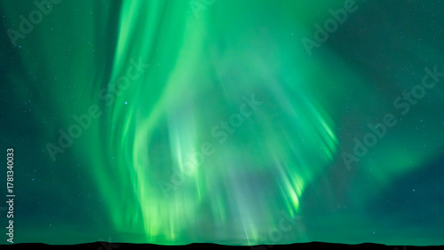 Aurora borealis dances across starry night sky