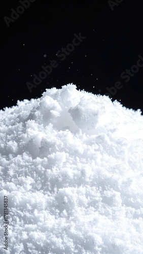 A textured mound of fine white powder against a solid black background