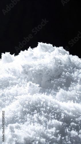 A detailed close-up of a textured white powder mound on a stark black background