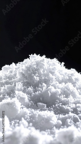 A high-contrast macro view of a white powder mound on a black background