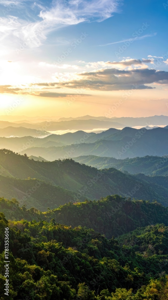 Fototapeta premium Golden sunrise over misty mountain ranges and lush, forested valleys