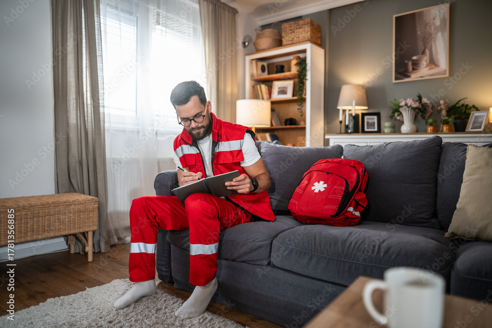 Obraz premium Male paramedic making home visit writing medical report