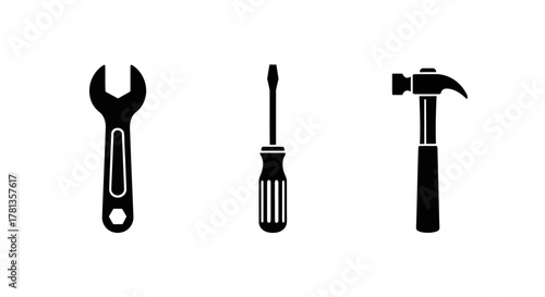 Silhouette icons of tools: wrench, screwdriver, and hammer on white background