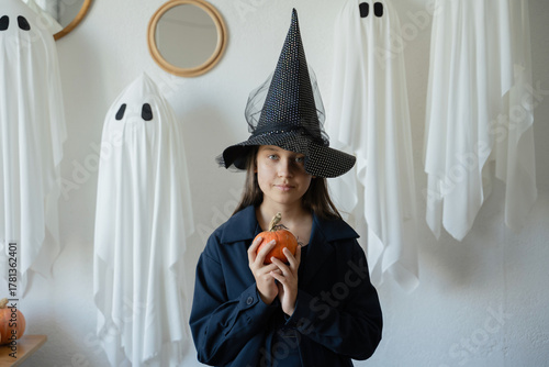 Halloween witch with ghosts and pumpkin in portrait