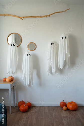 Halloween indoor decor with ghost figures and pumpkins