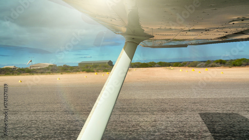 Scenic view of small plane taking off from dusty outback runway in Western Australia