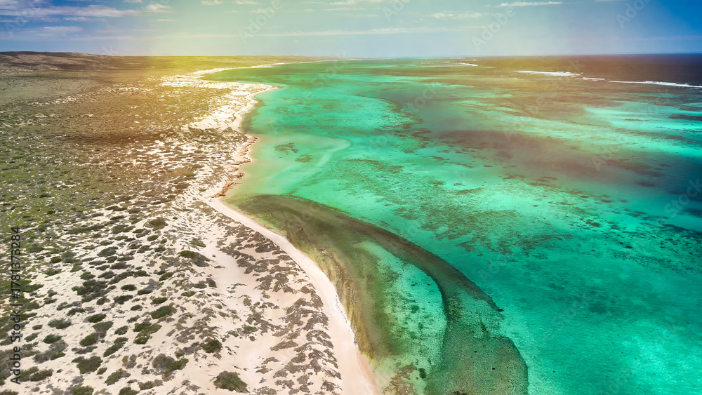 Fototapeta premium Panoramic aerial view of Osprey Bay WA with boats, reef, and scenic shoreline under bright sunlight