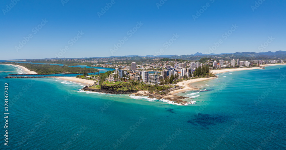 Fototapeta premium Aerial views of the Coolangatta coastline and skyline with Snapper Rocks and Rainbow Bay in the foreground and Fingal Head and Mount Warning in the background
