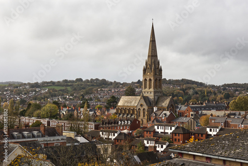 High view point of St Michael and All Angels Church, nestled among the rooftops of Exeter. It clearly shows the spire standing above the houses. There is space for text