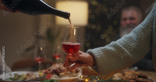Celebration dinner with family, pouring drinks and enjoying festive meal in cozy setting