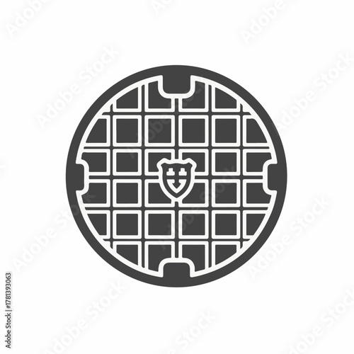 Manhole cover design with intricate pattern featuring emblem and grid layout. This manhole cover showcases a distinctive emblem in center with structured,